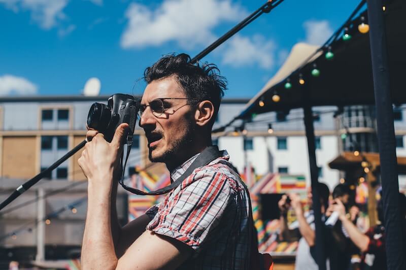 A man holding a camera up to his face